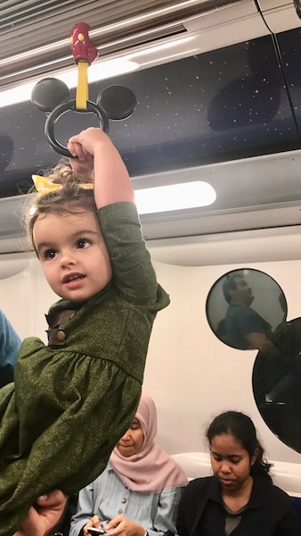 a child holding a handle on a subway