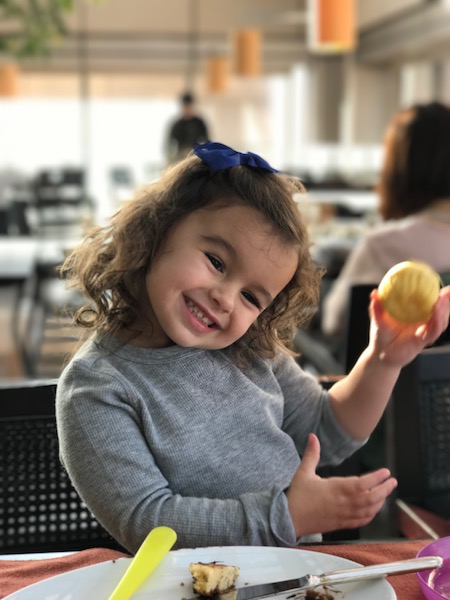 a girl holding a yellow ball