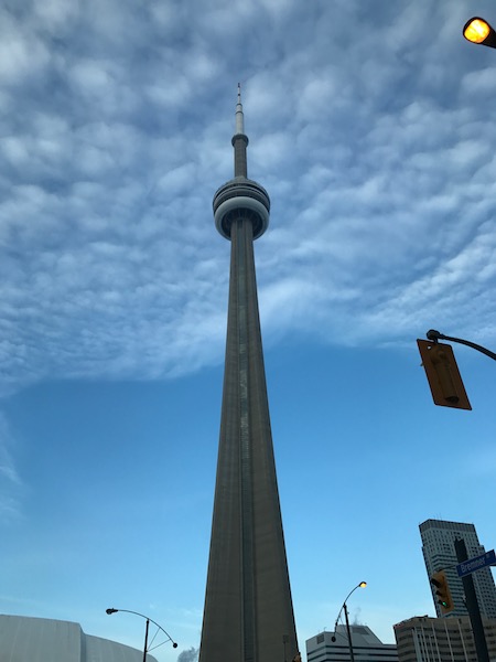 a tall tower with a pointy top with CN Tower in the background