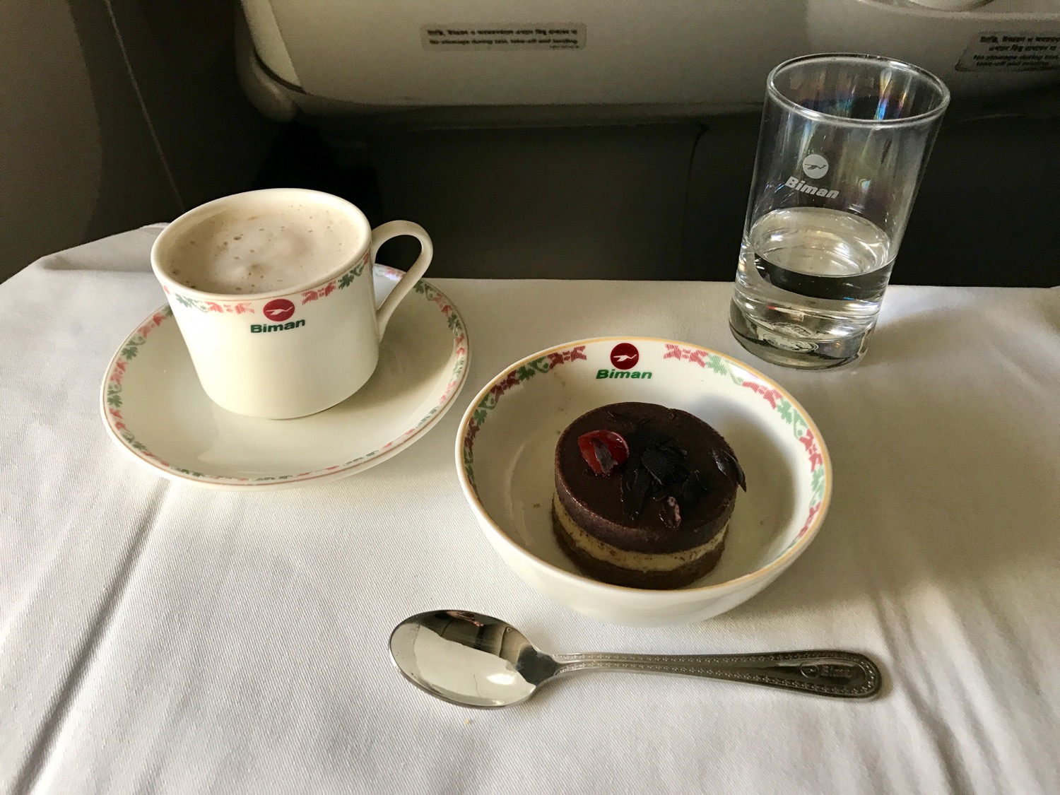 a plate with a cup and saucer with a dessert on it