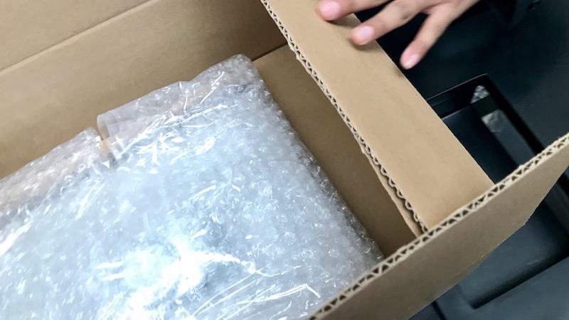 a hand opening a box with bubble wrap