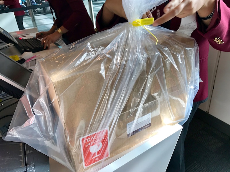 a person holding a plastic bag over a box