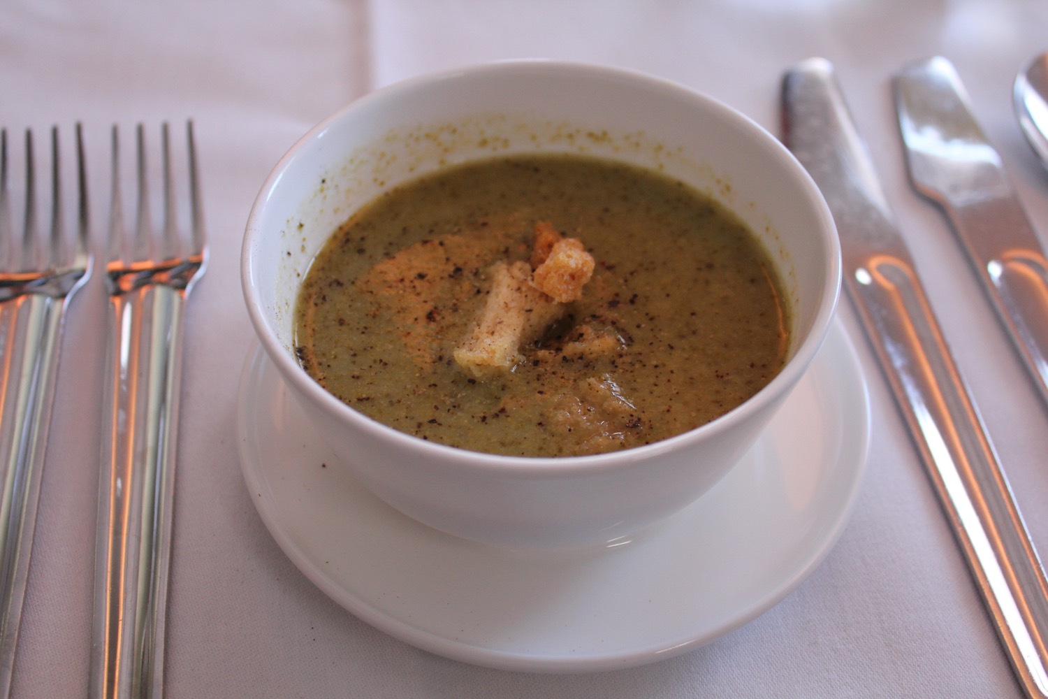 a bowl of soup with a fork and knife