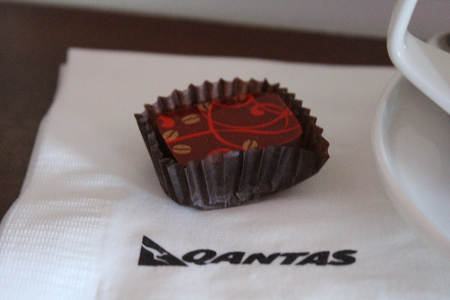 a chocolate in a wrapper on a napkin