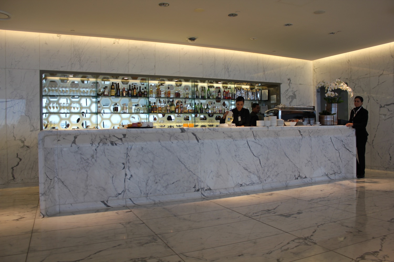 a marble counter with a bar and shelves of liquor