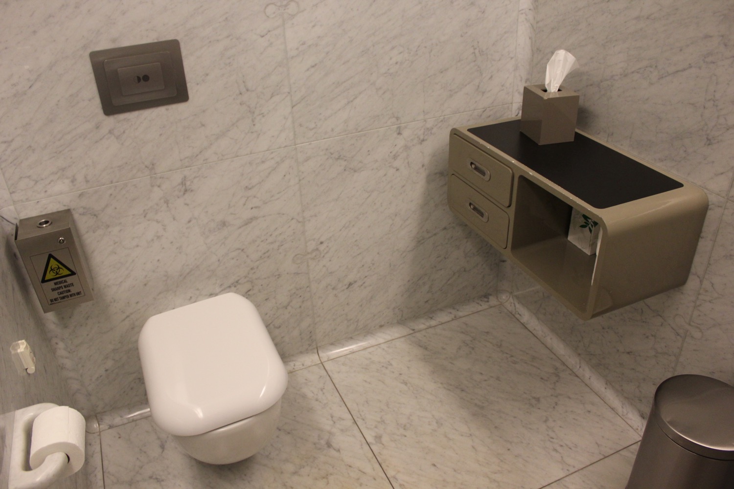 a toilet and a shelf in a bathroom