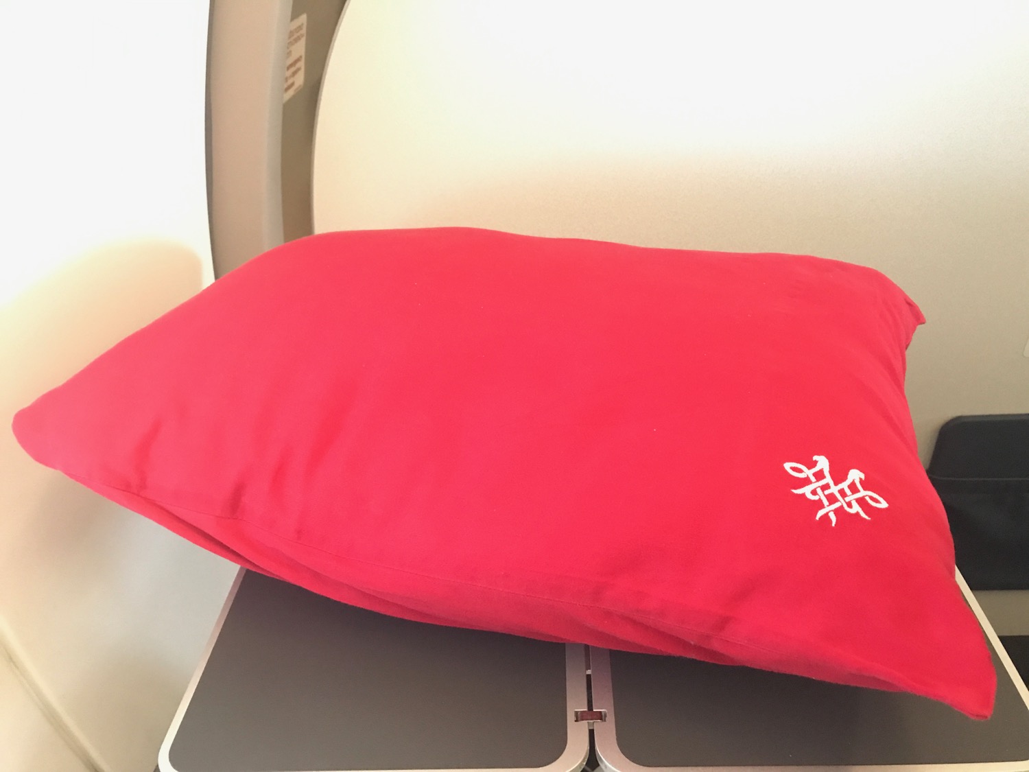 a red pillow on a grey surface