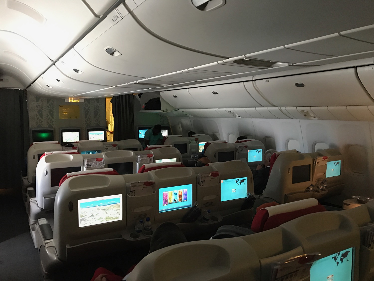 a group of people sitting in an airplane with computers