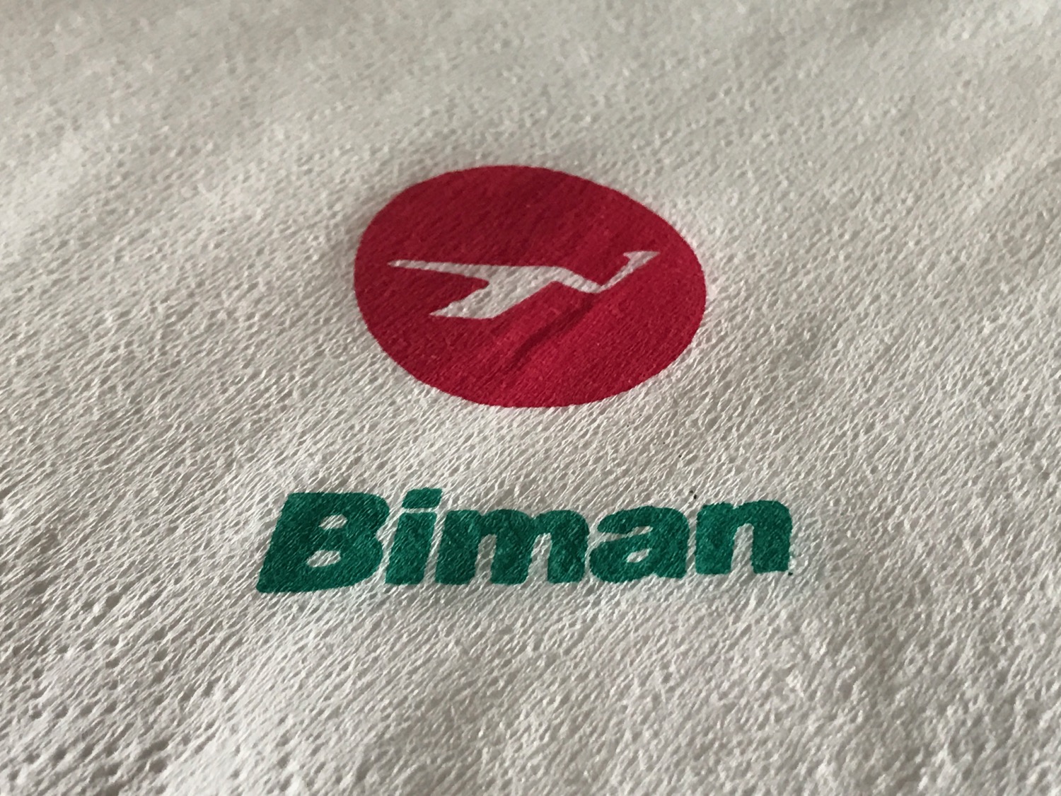 a white towel with a red circle and a logo on it
