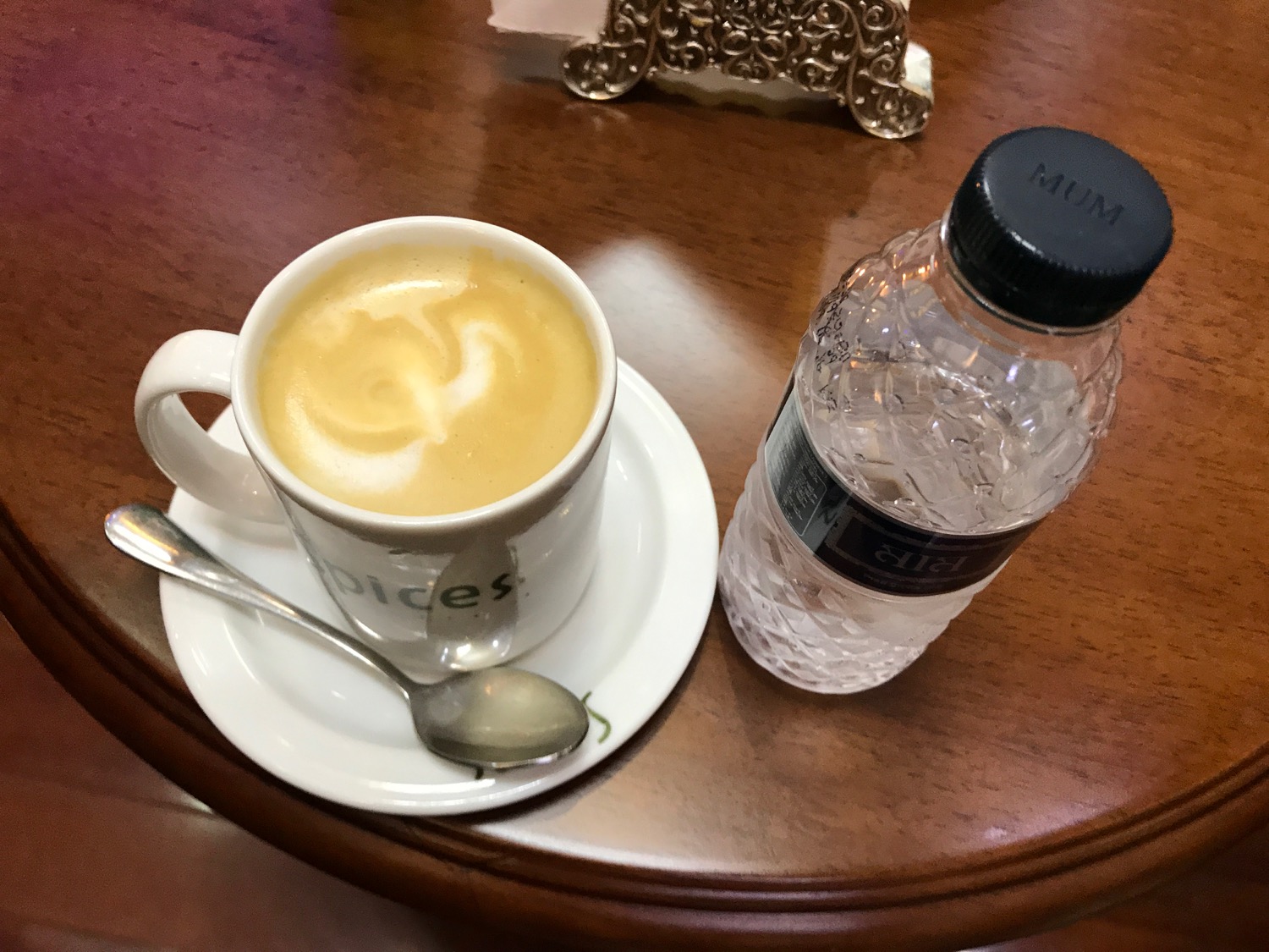 a cup of coffee and a bottle of water on a table