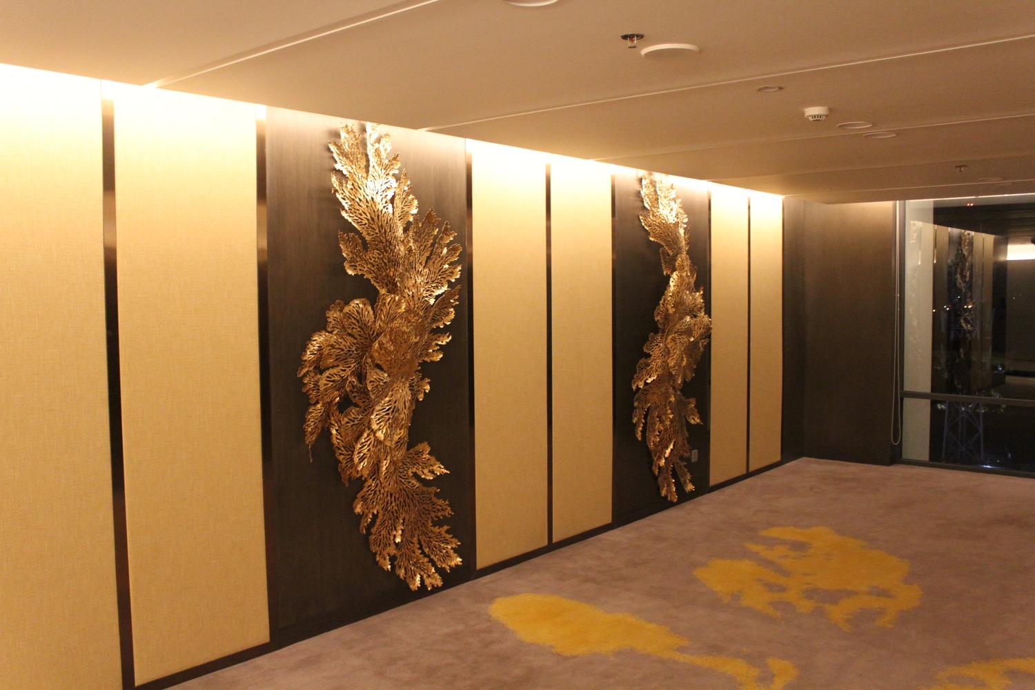 a room with a wall with gold art on it