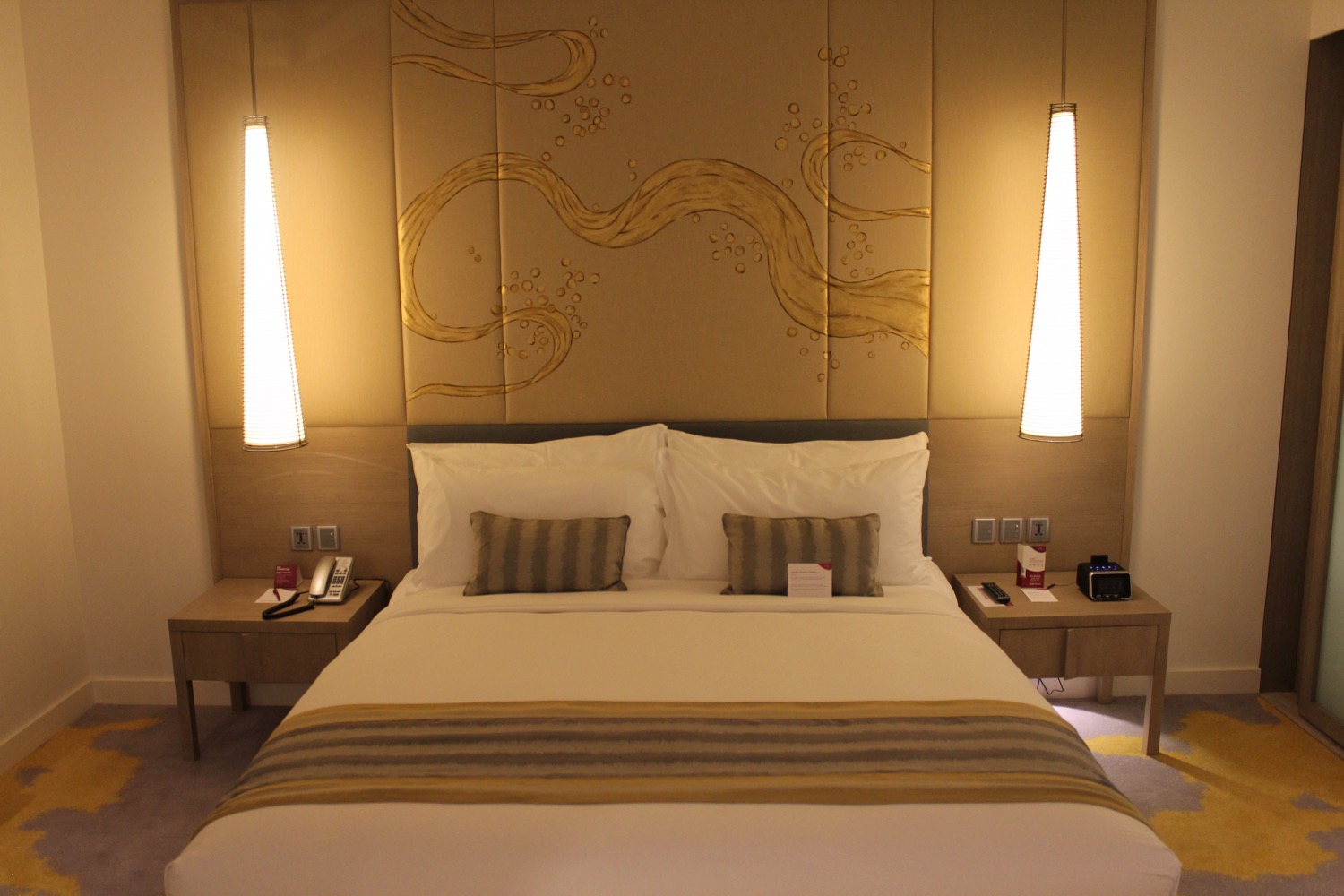 a bed with two lamps above it