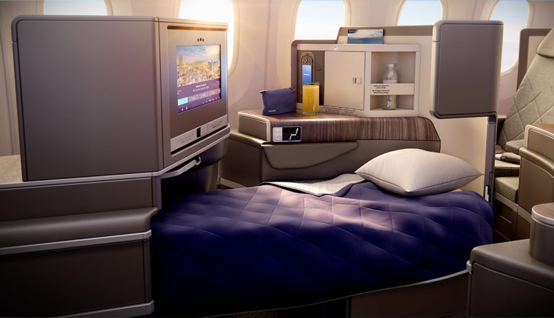 a bed with a tv and a pillow in the middle of a plane