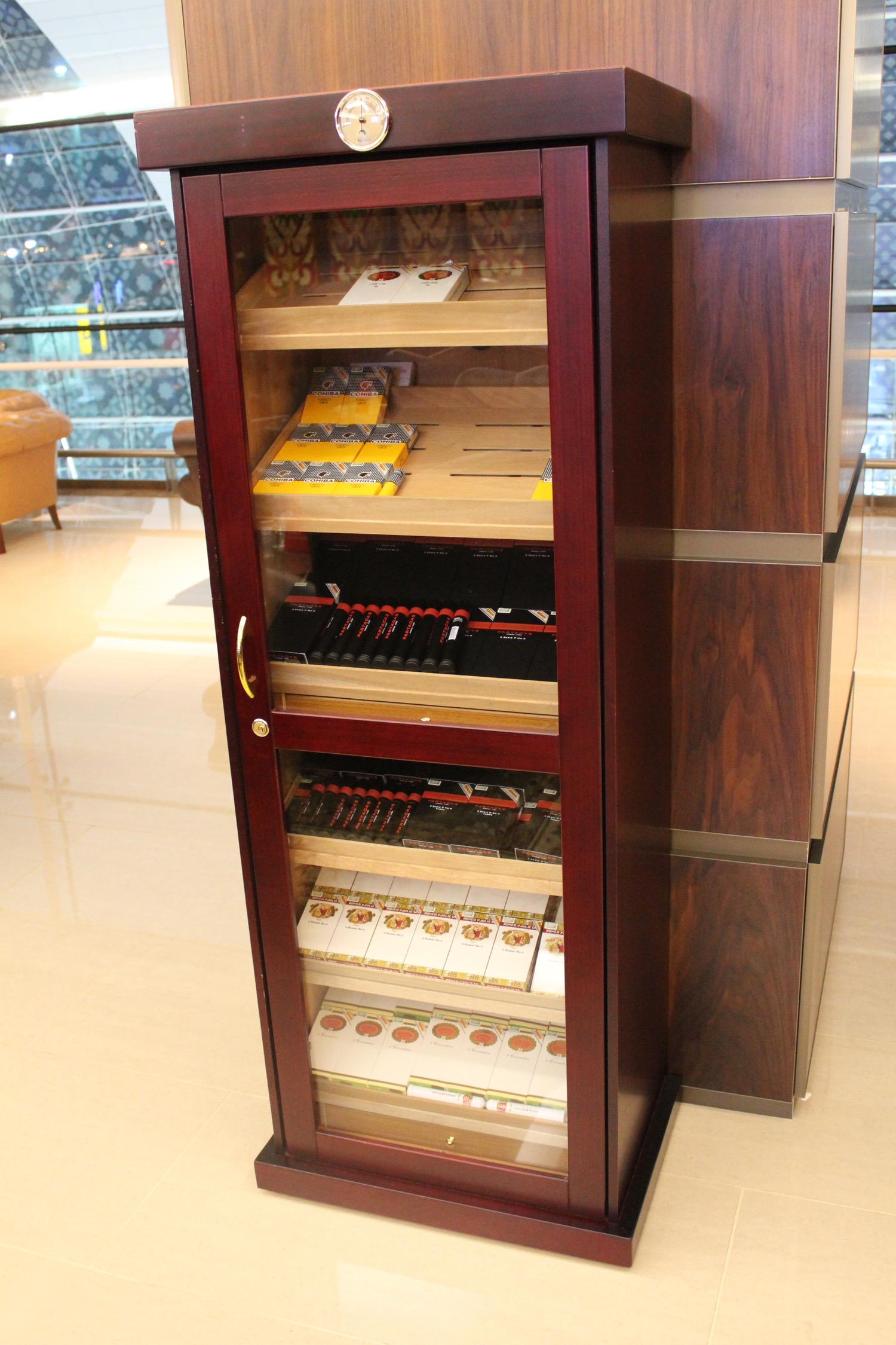 a wooden cabinet with a shelf full of cigarettes and pens