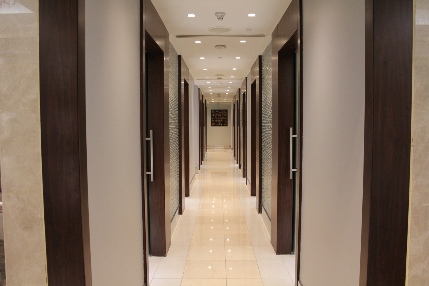 a long hallway with doors and a tile floor