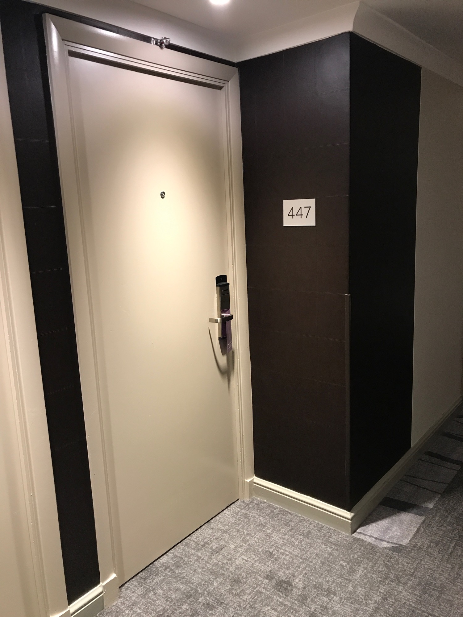 a white door with a black wall and a number on it