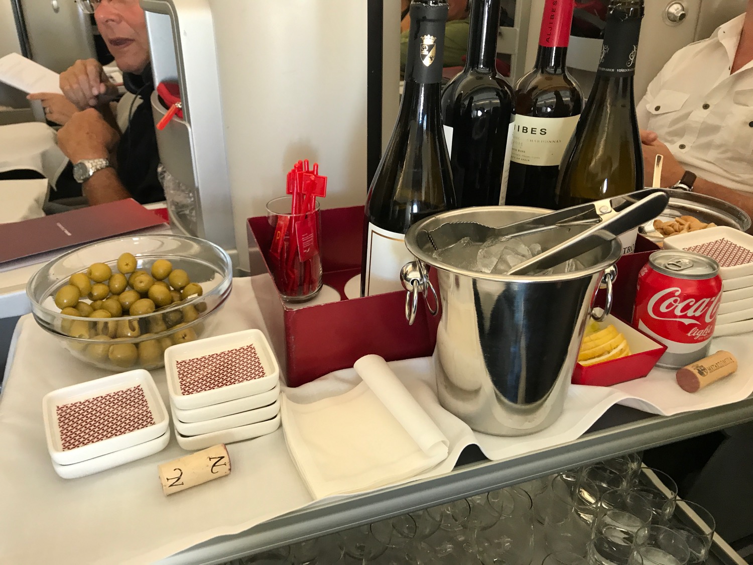 a table with bottles and a bucket of olives