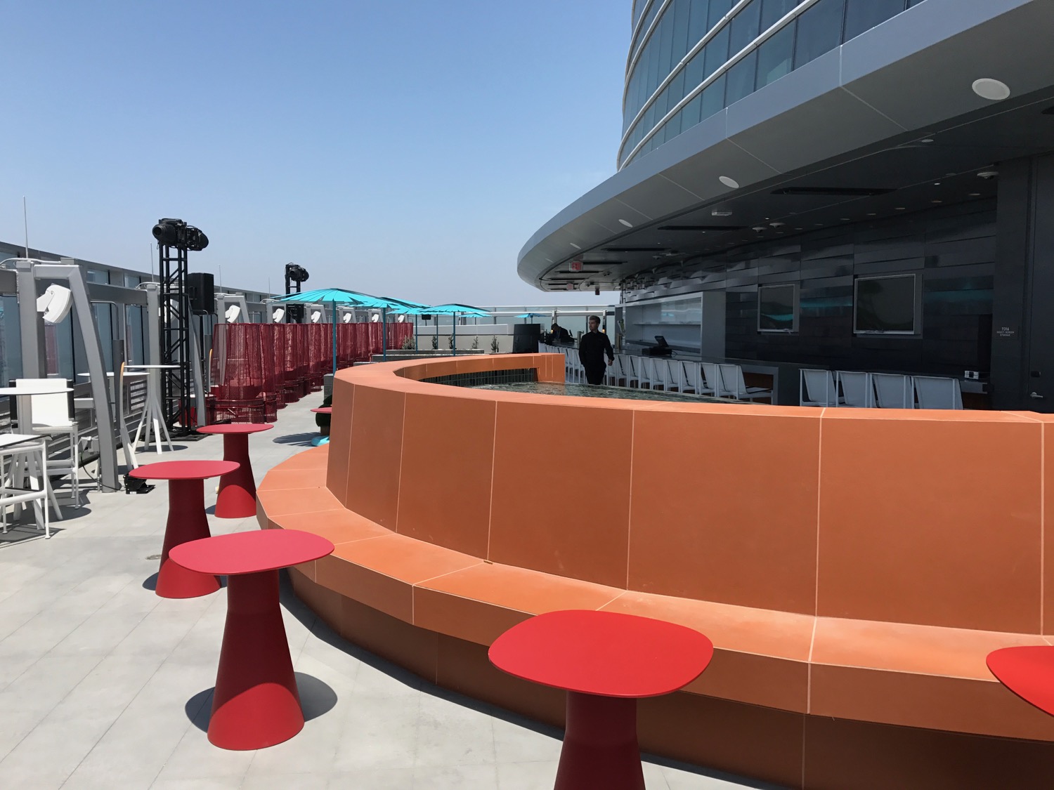 a round orange table and red tables outside a building