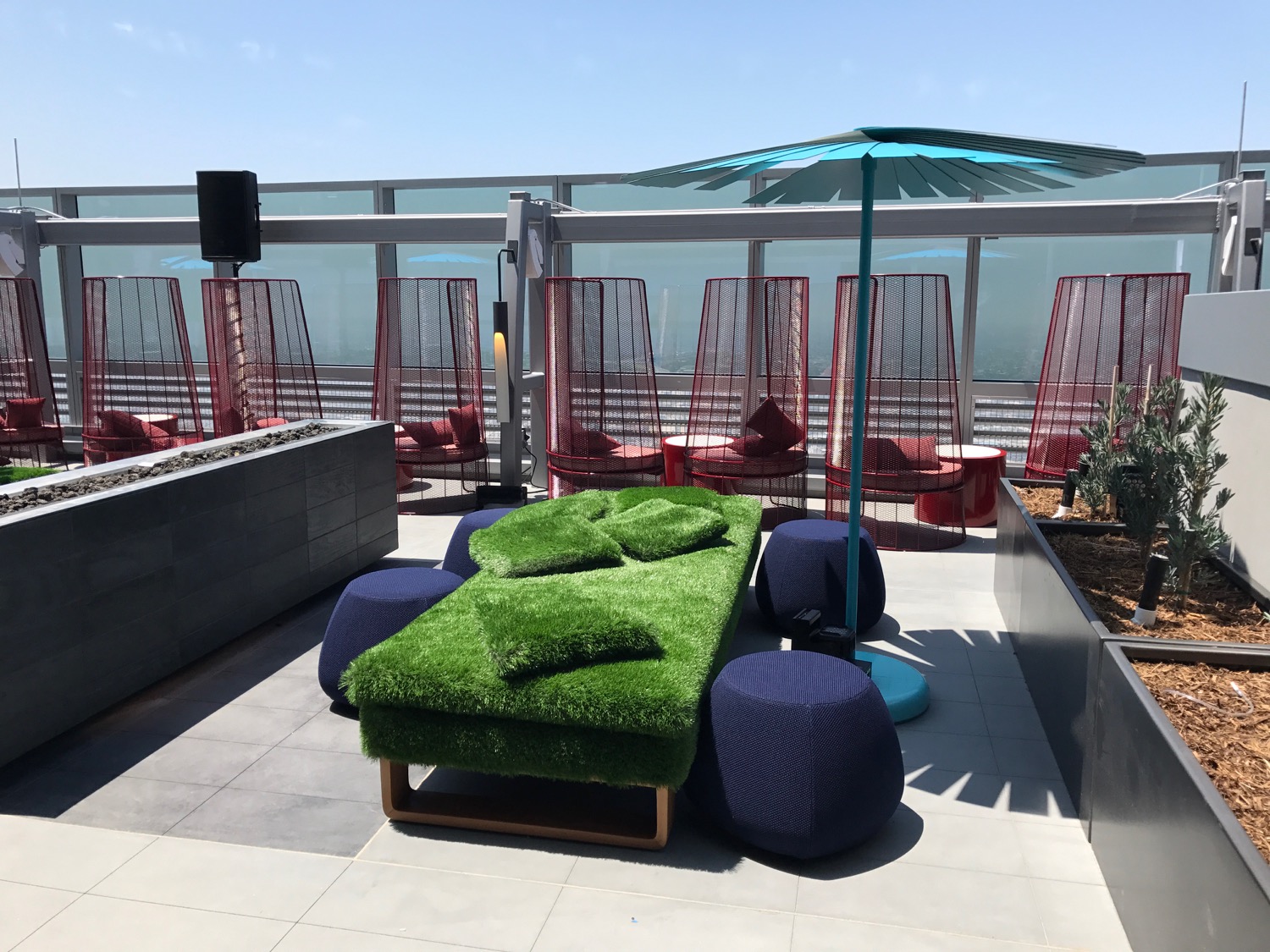 a green couch and blue chairs on a rooftop
