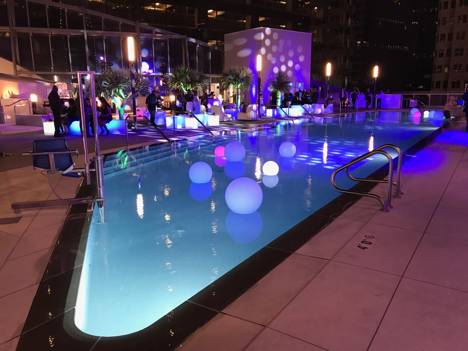 a pool with lights and people around it