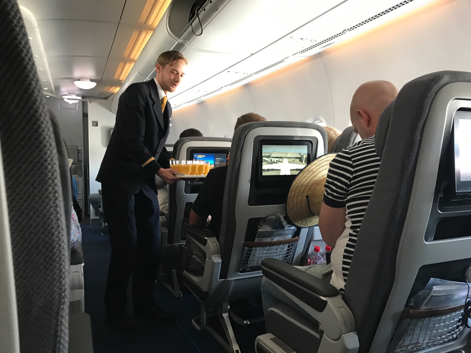 a man serving drinks on an airplane