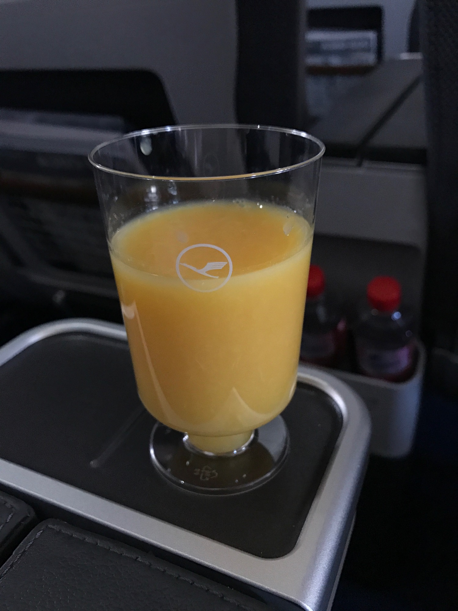 a glass of orange juice on a tray