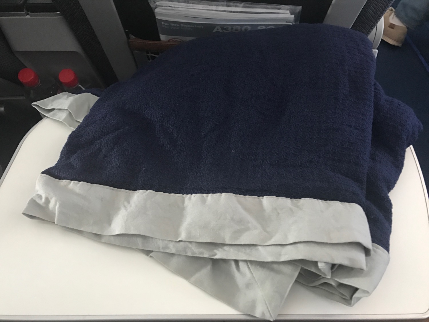 a blue and grey blanket on a white surface