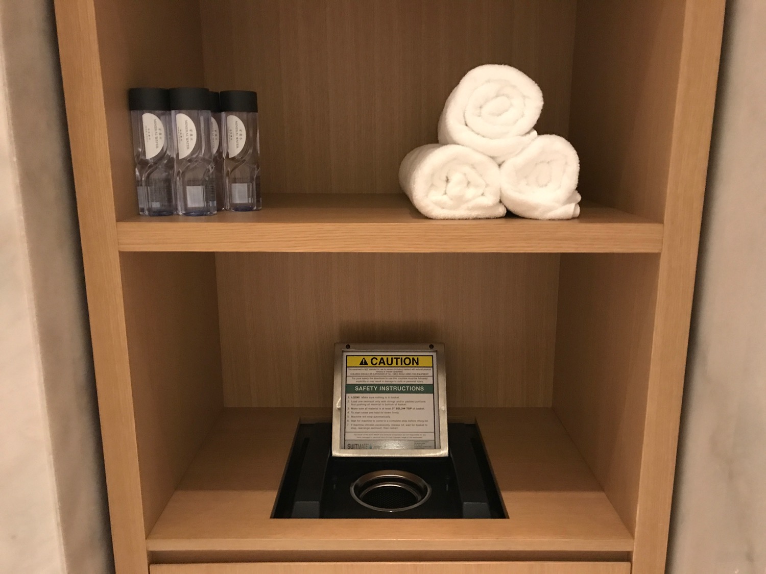 a shelf with towels and bottles on it