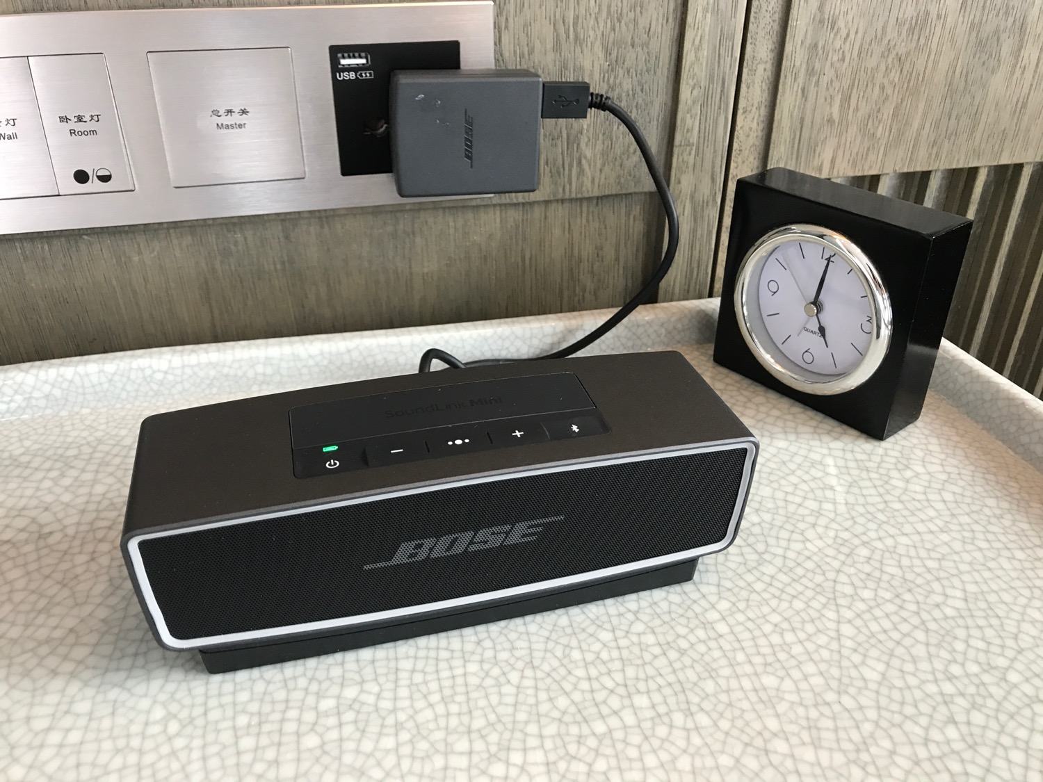 a black speaker with a black charger plugged into it