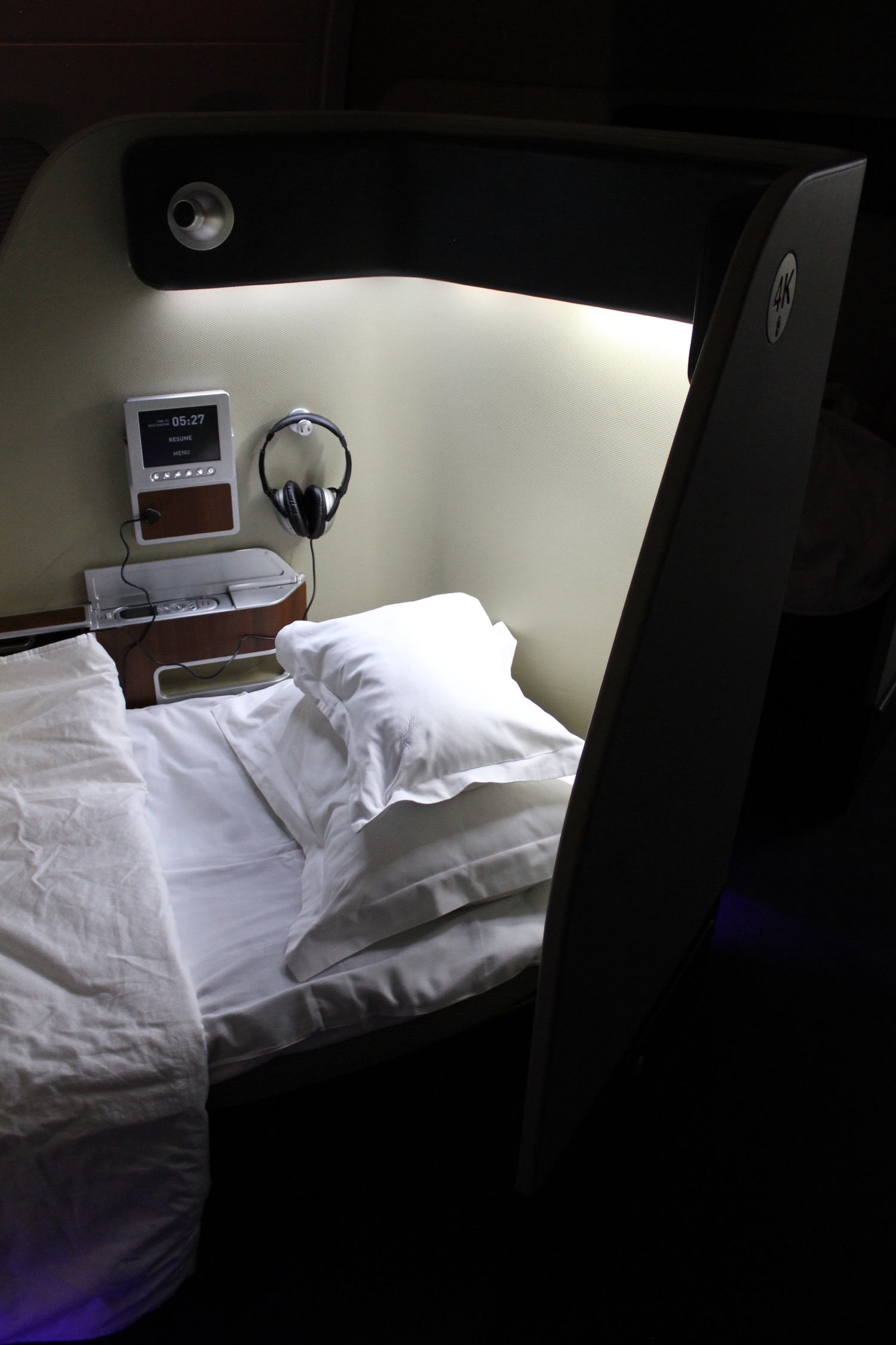 a bed with white sheets and headphones