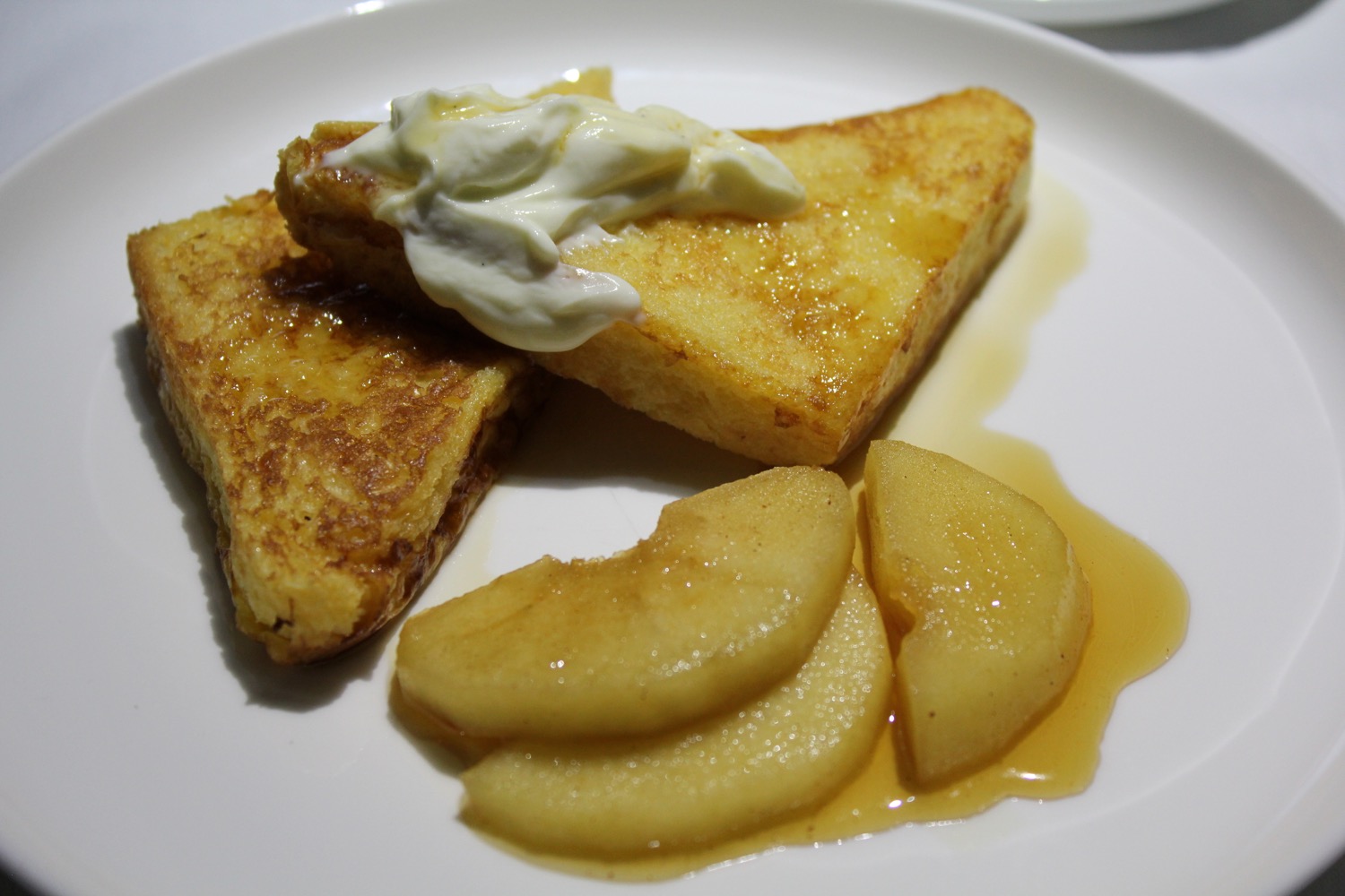 a plate of french toast and sliced apples
