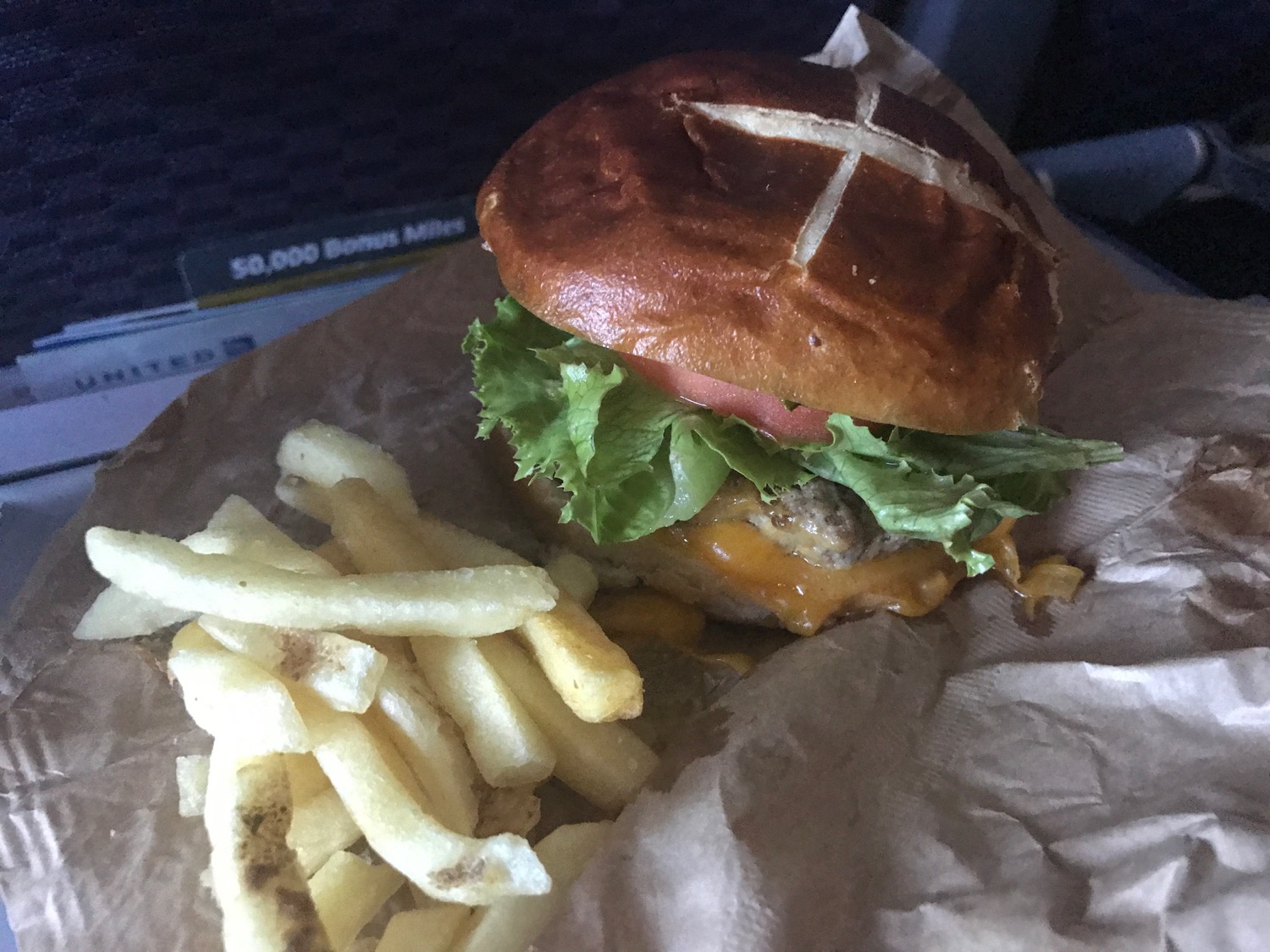 a burger and fries on a paper wrapper