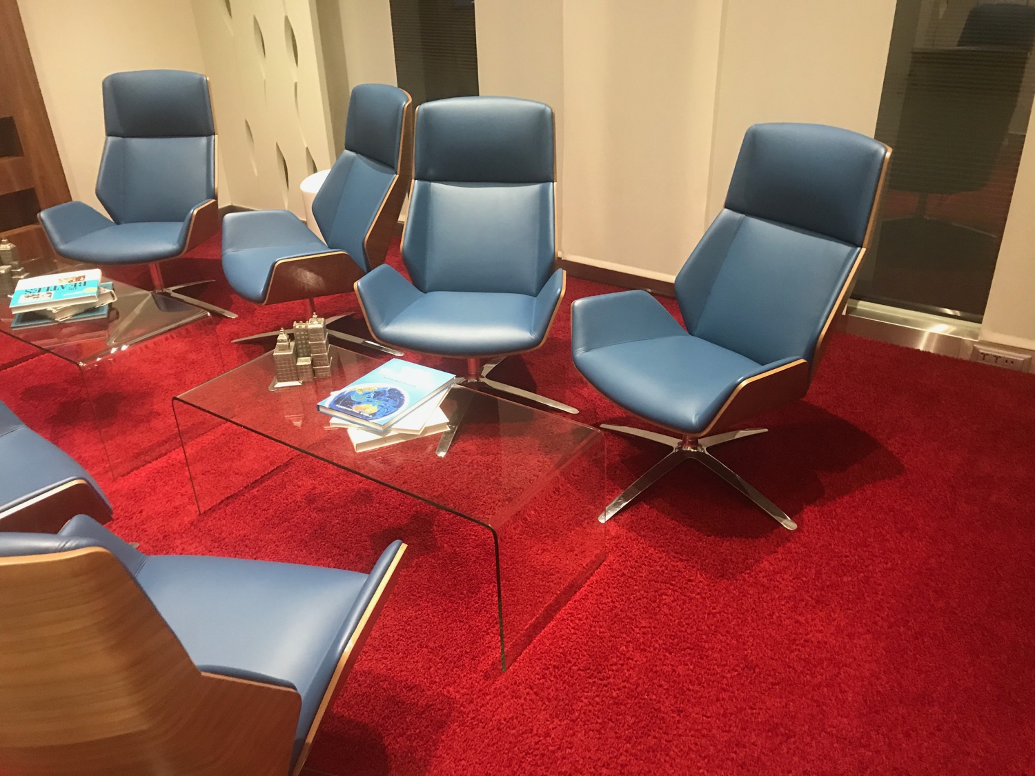 a group of blue chairs on a red carpet