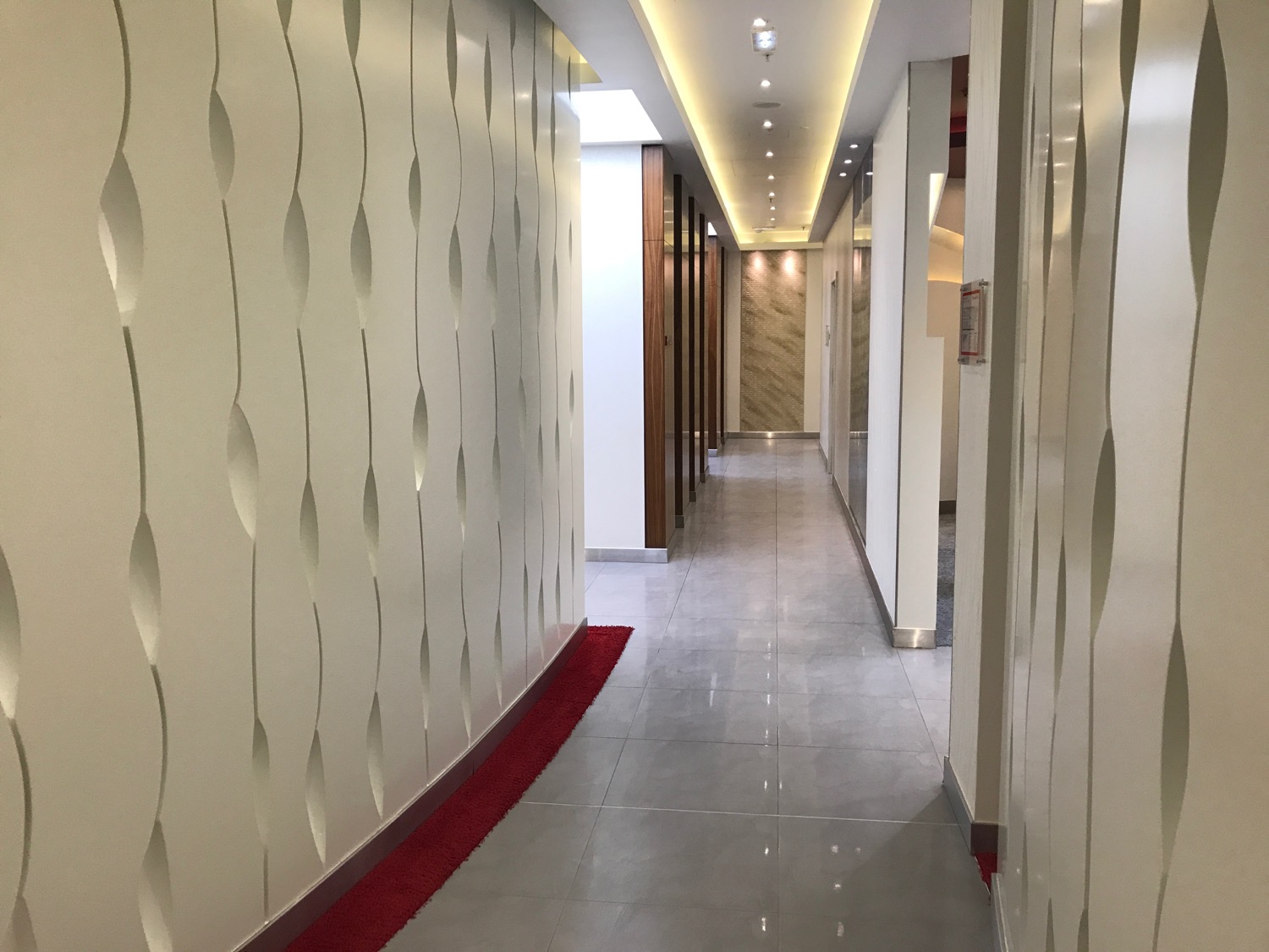 a hallway with white walls and red carpet