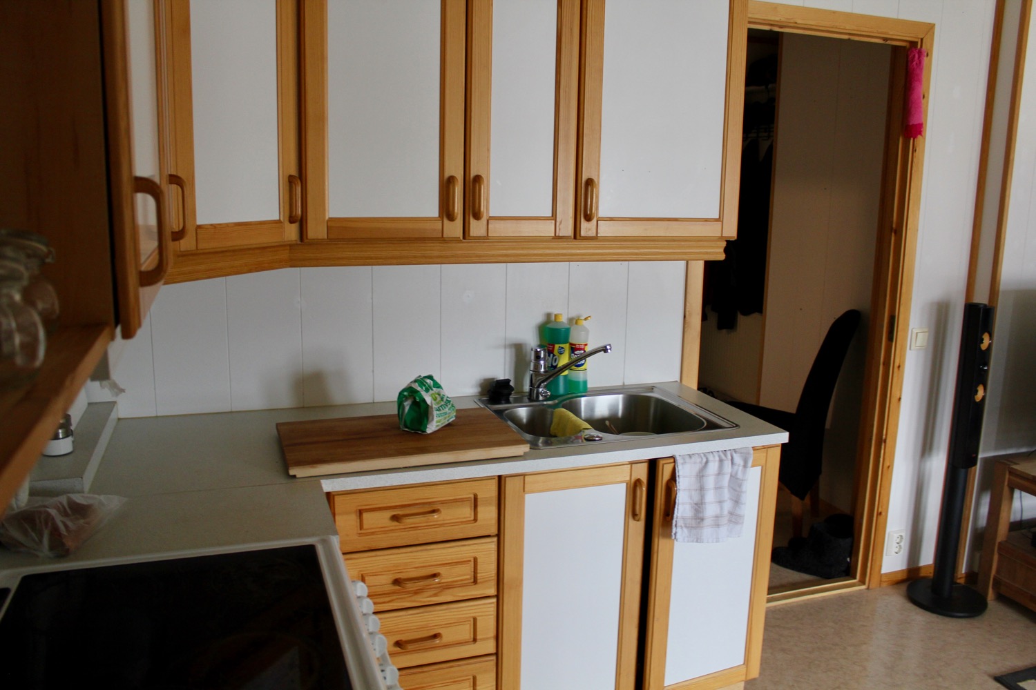 a kitchen with white cabinets and wooden cabinets