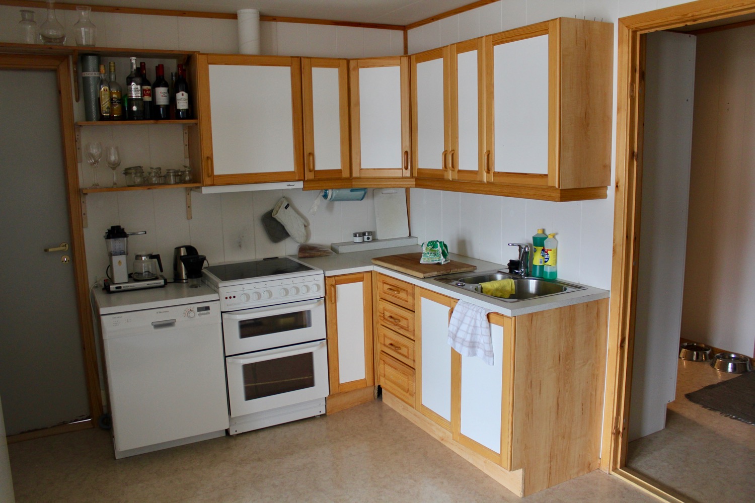 a kitchen with white cabinets and wooden cabinets