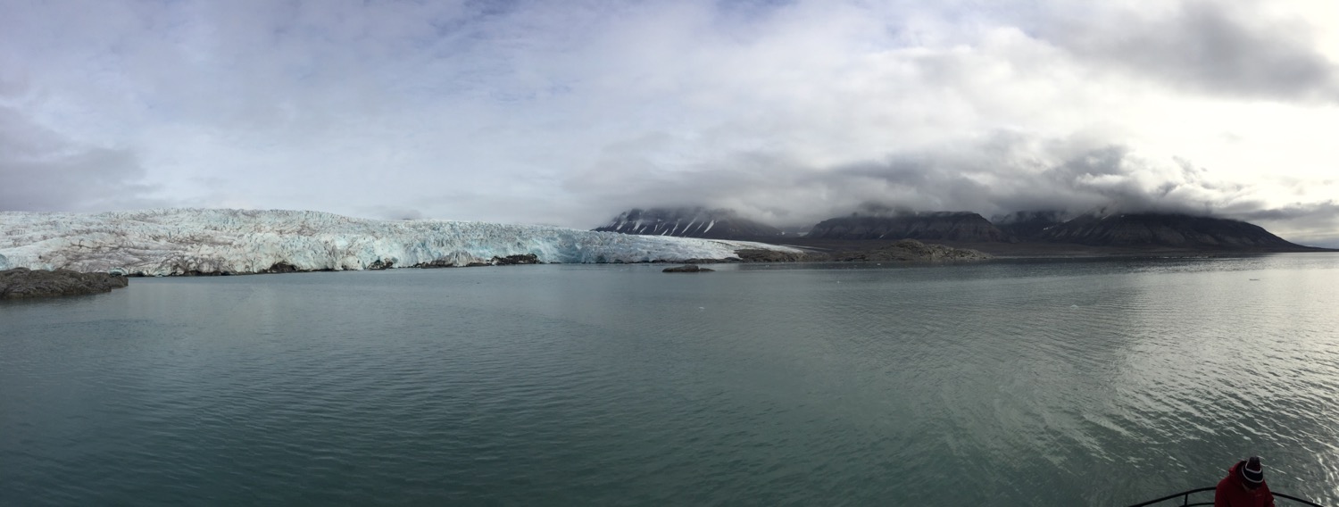 a body of water with a glacier in the background