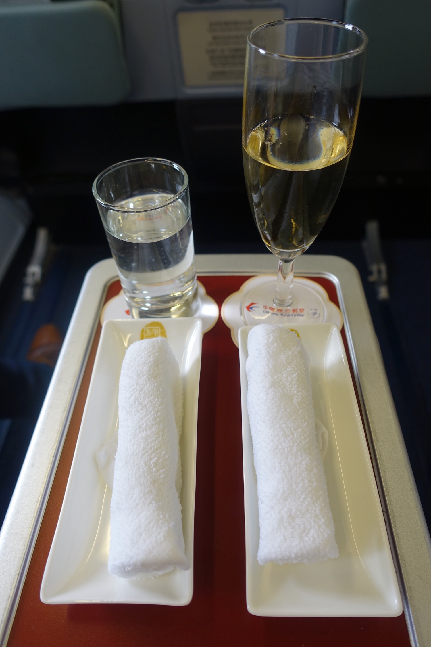 a glass of champagne and two plates of food on a tray