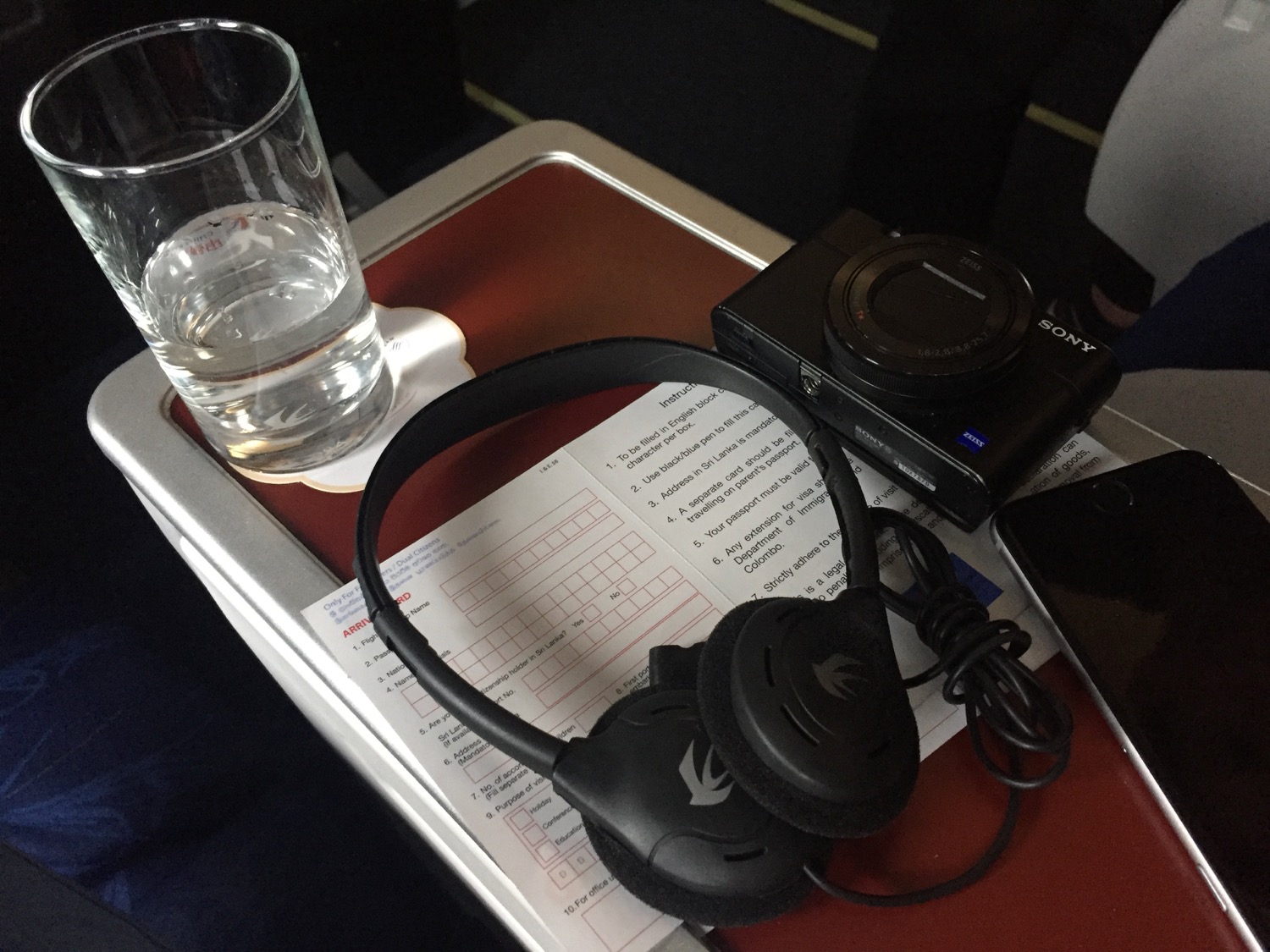 a black headphones and a glass of water on a tray