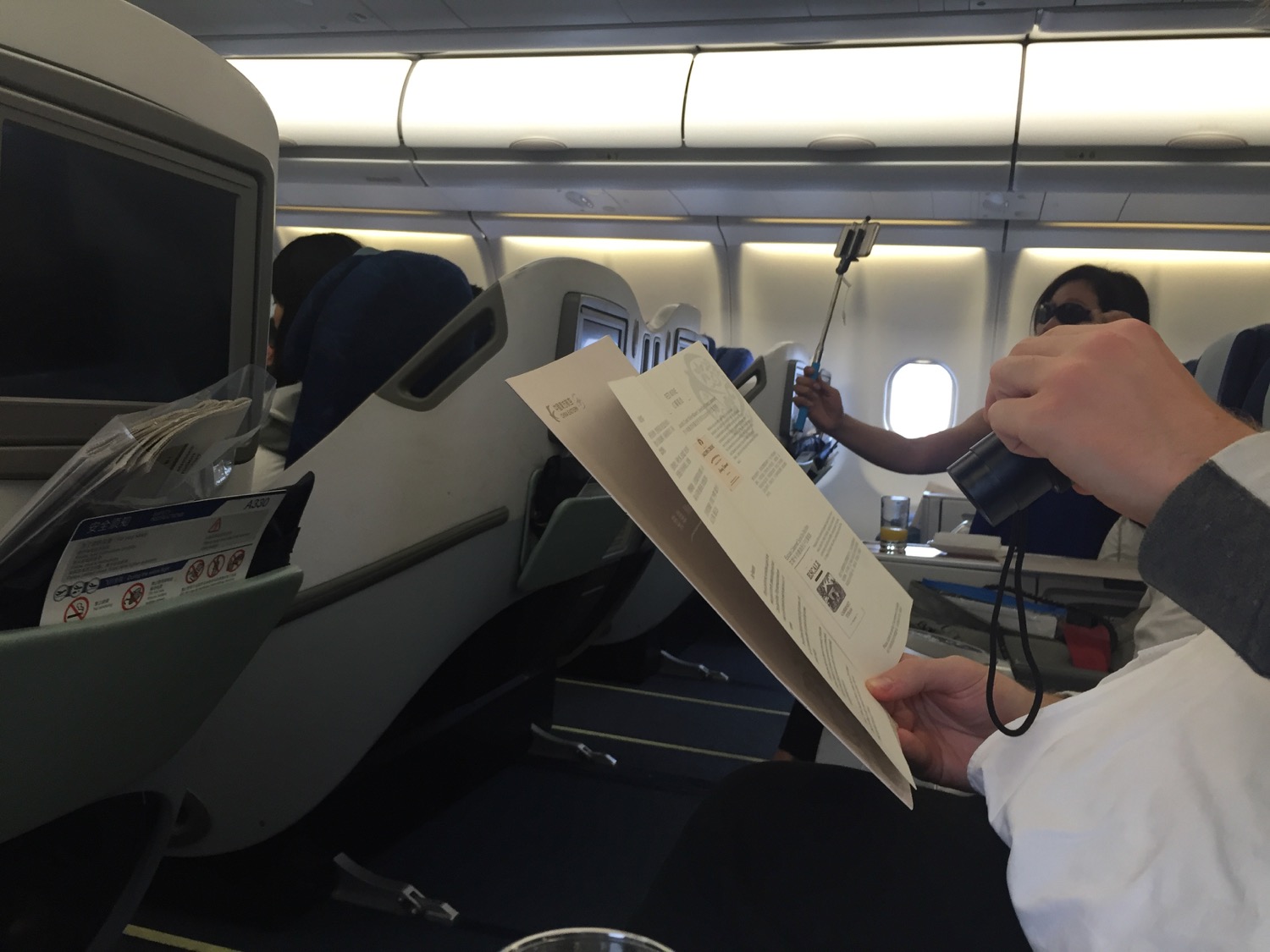 a person holding a paper in an airplane