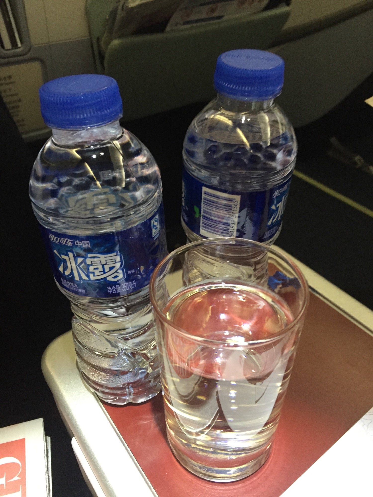 a group of water bottles and a glass of water