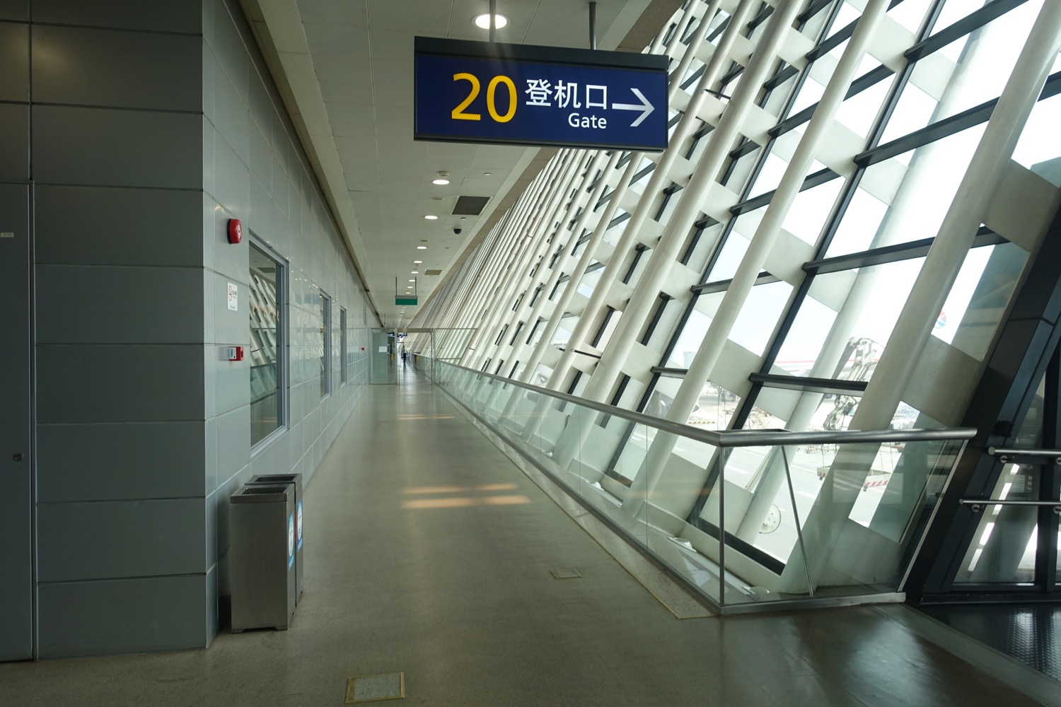 a walkway with a sign and a glass wall