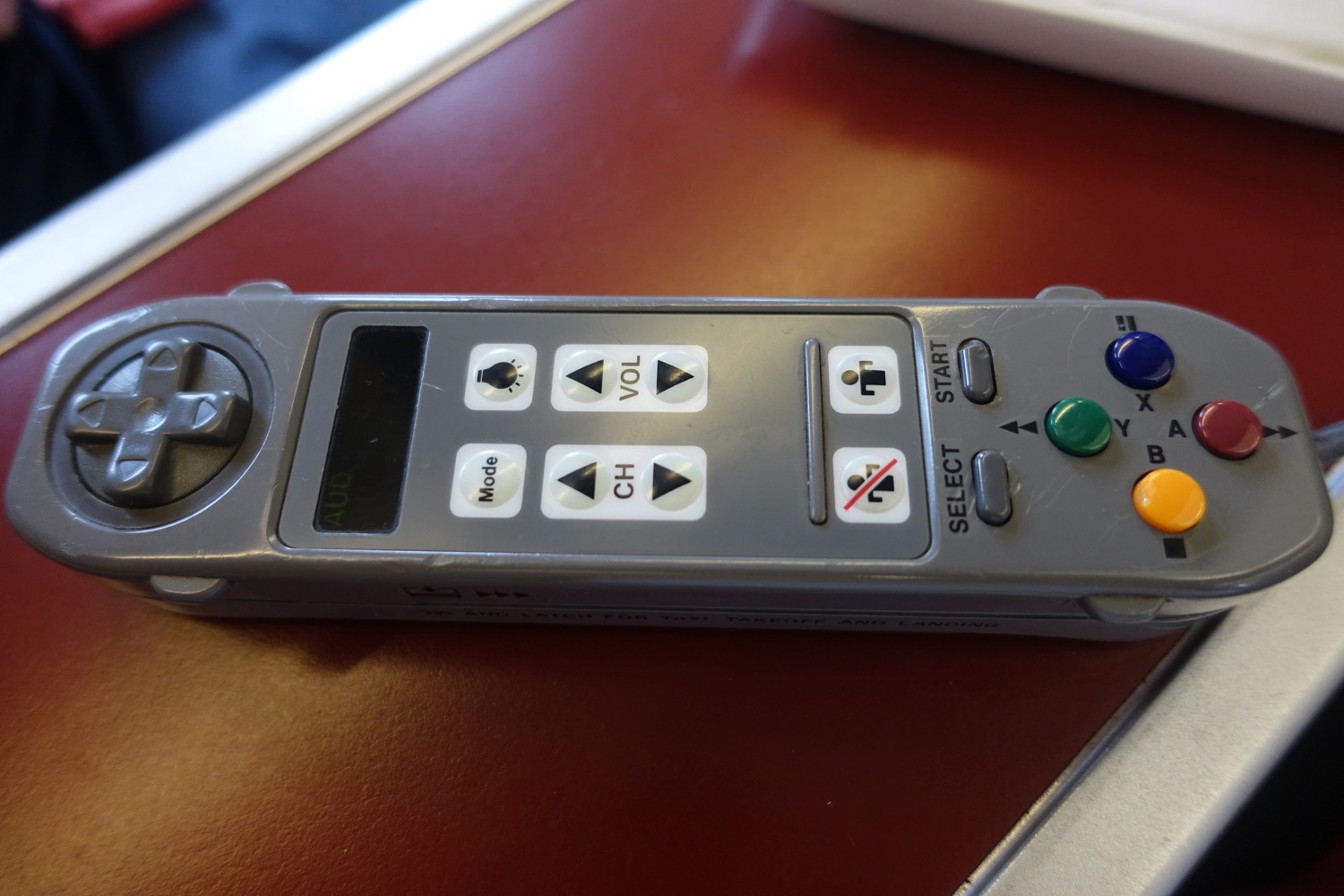 a grey remote control with buttons and buttons