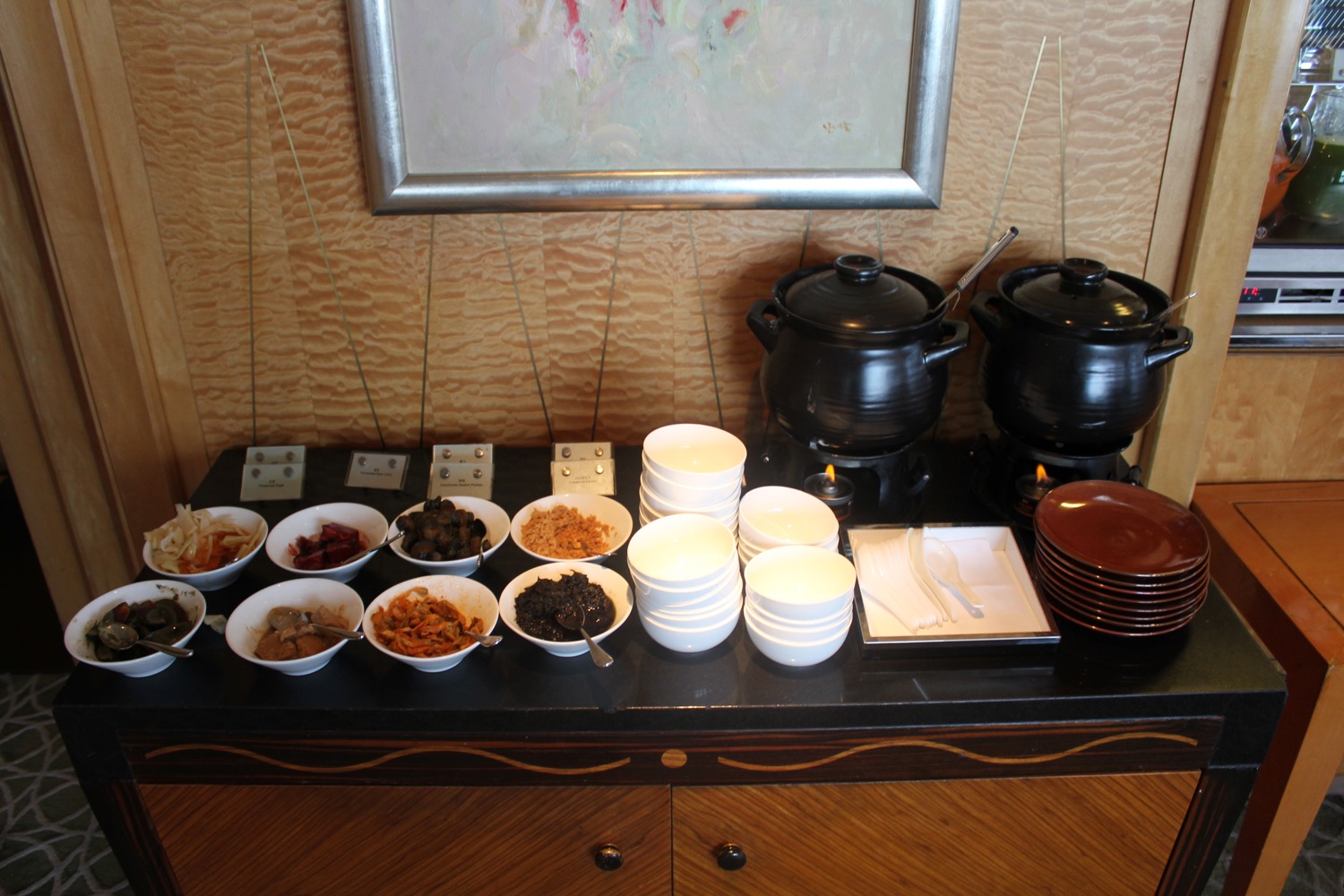 a buffet table with bowls of food and utensils