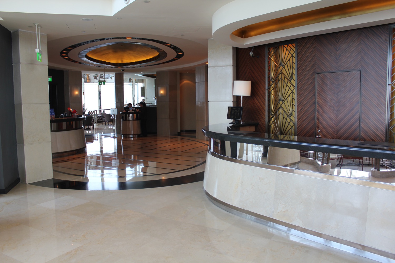 a lobby with a round counter and a wood and gold ceiling