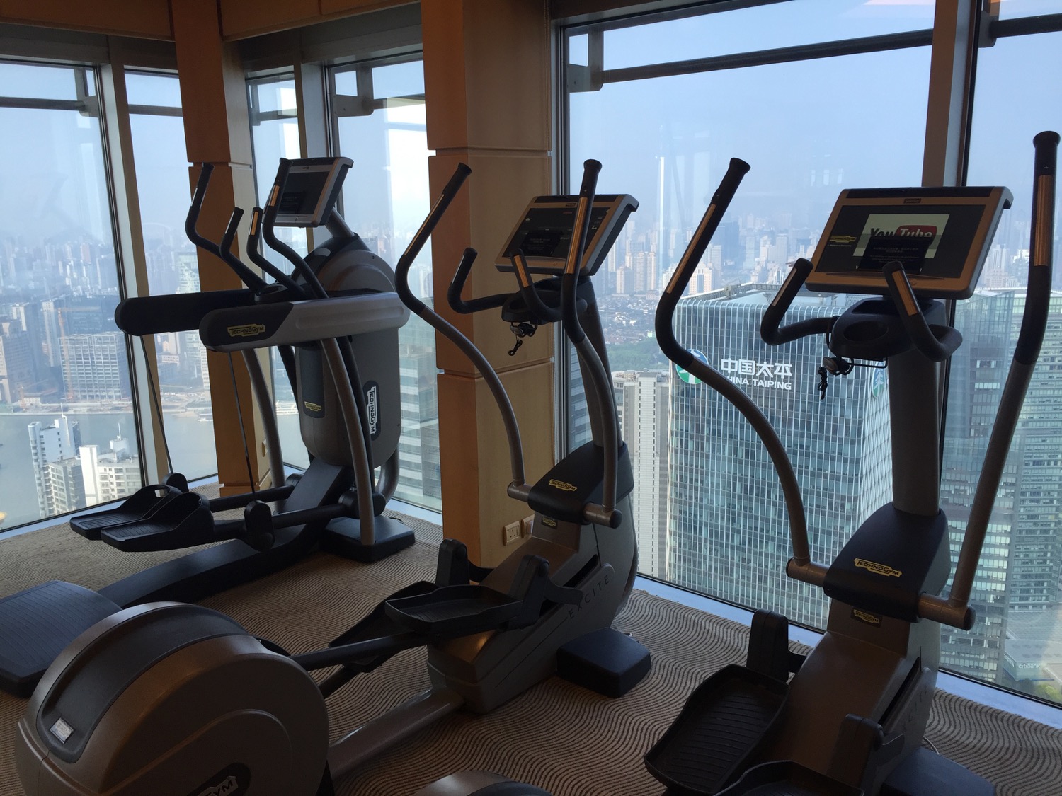a group of exercise machines in a room with windows