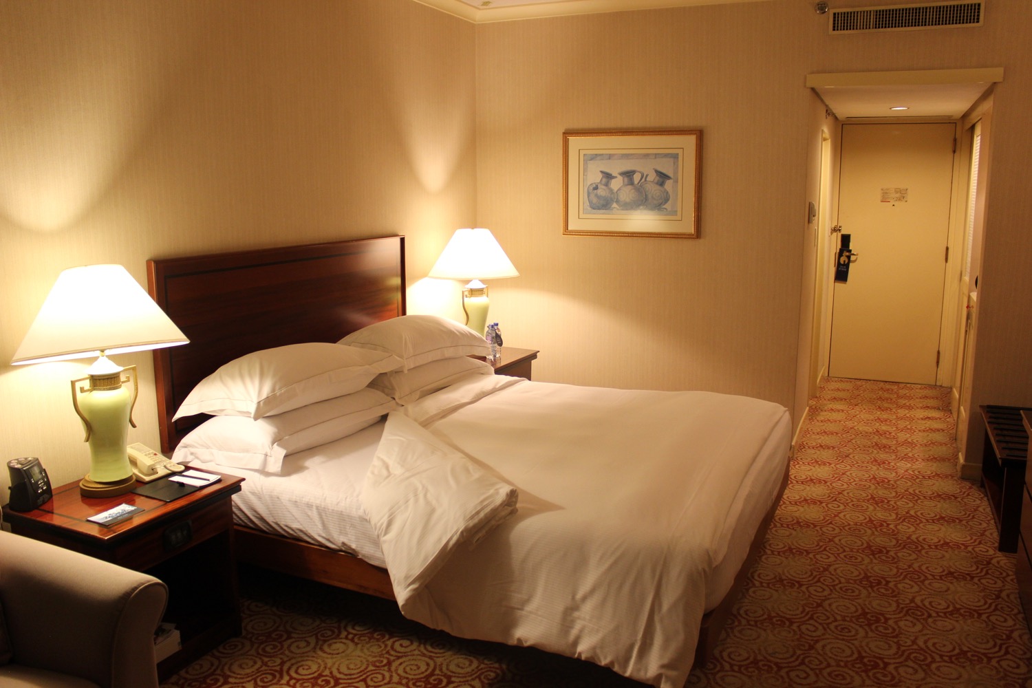 a bed with pillows and lamps in a hotel room