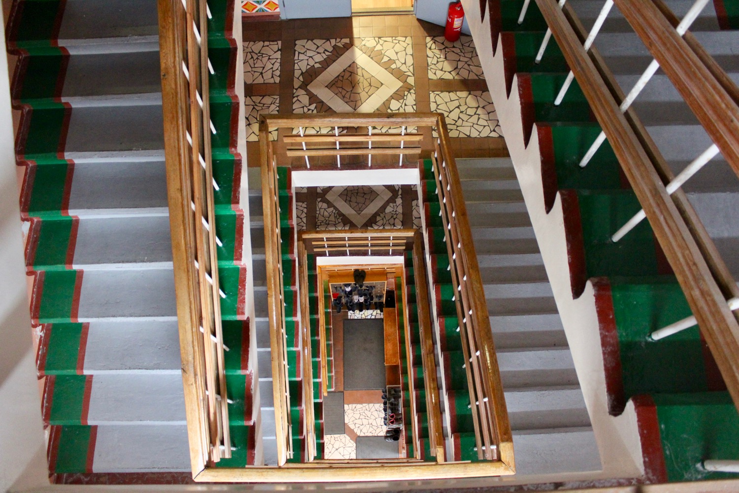 a staircase with green and red railings