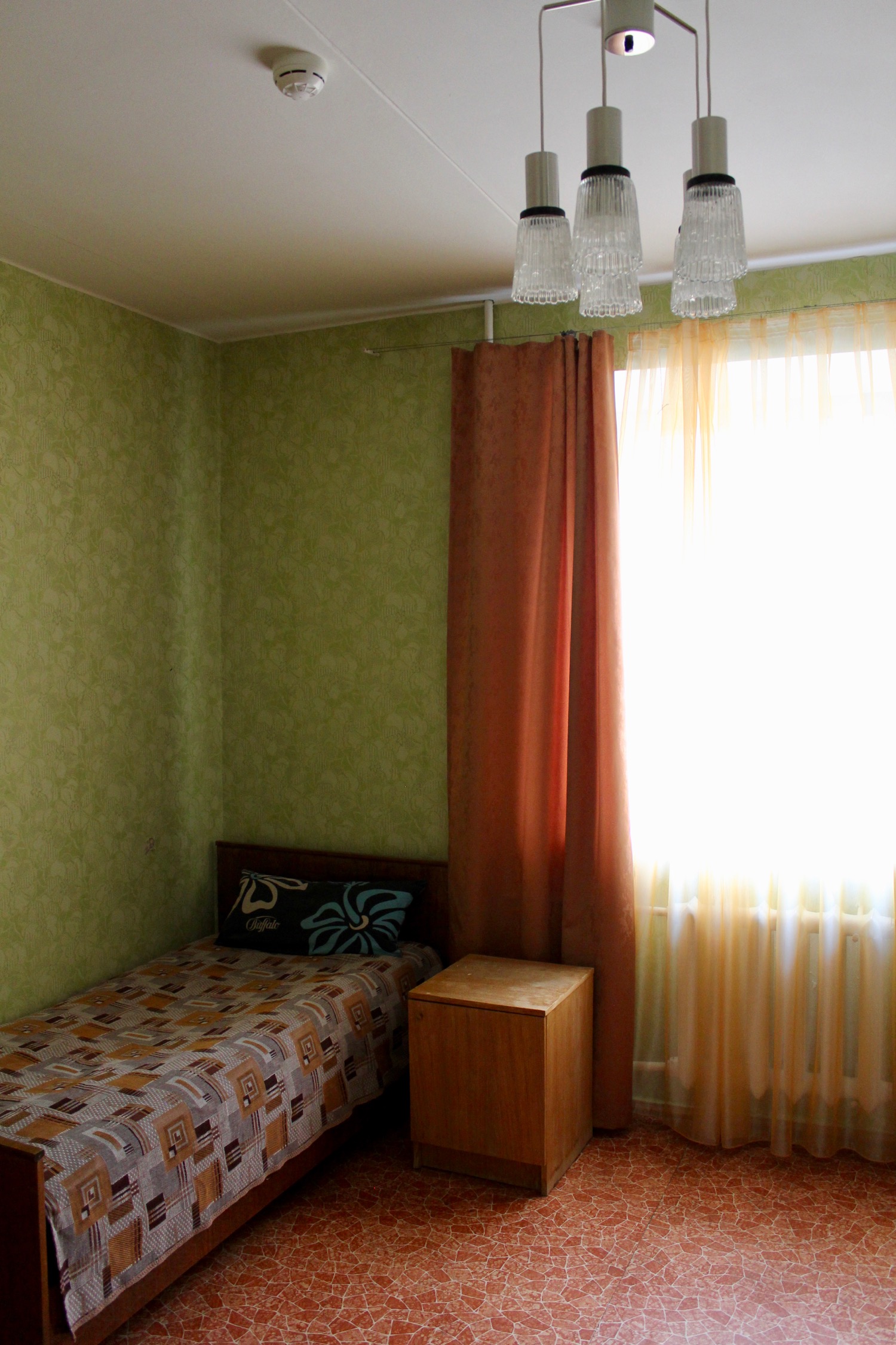 a bedroom with a bed and a table and a lamp