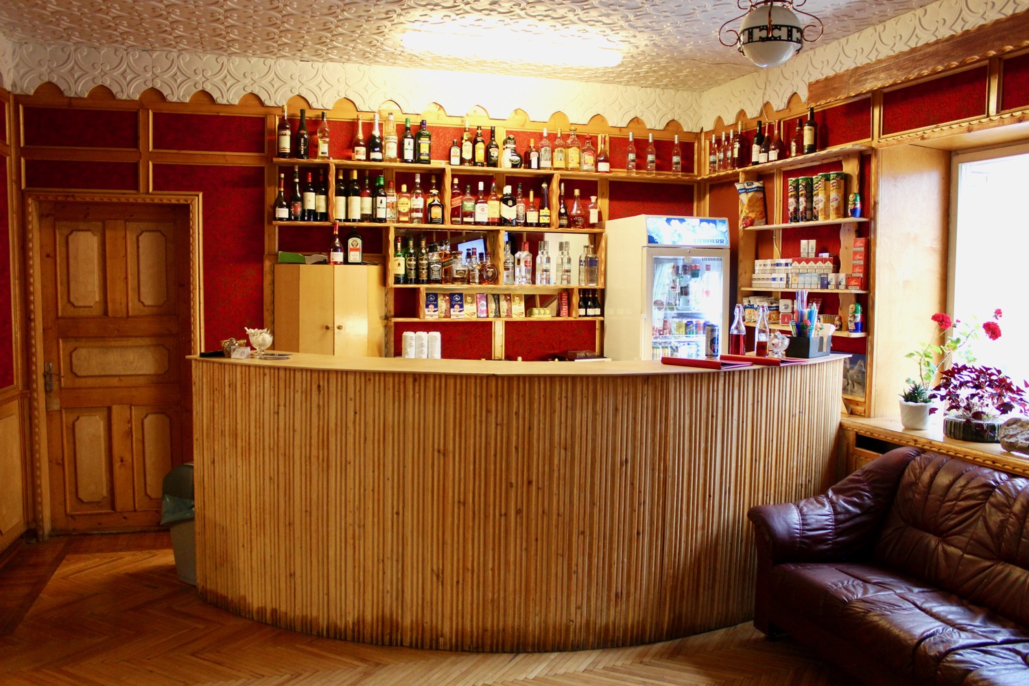 a bar with a chair and shelves of liquor